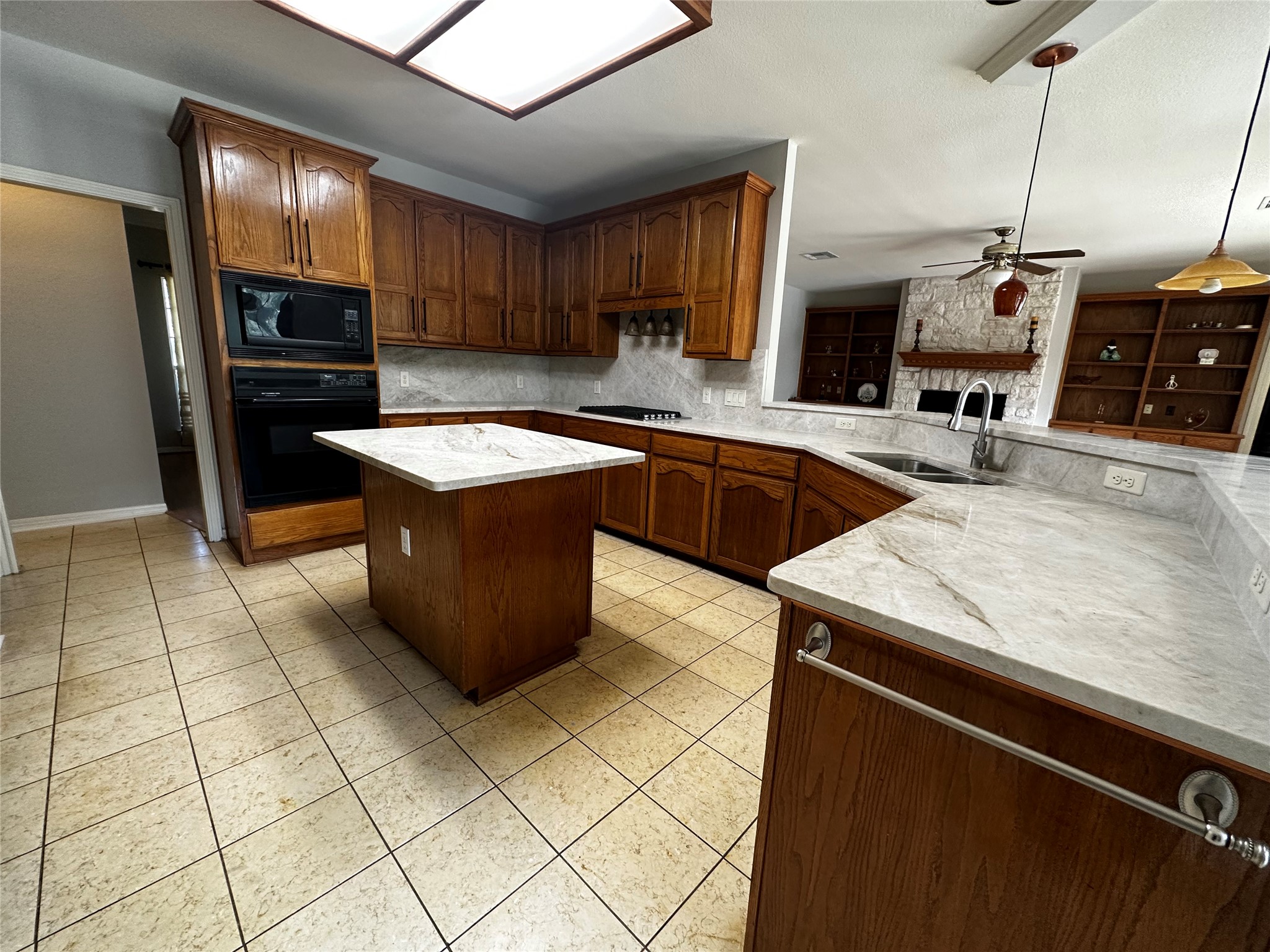 13615 Copperleaf Trail Manchaca, TX 78652 - Photo 14 of 39 Kitchen with pendant lighting, a center island, black appliances, a peninsula, and backsplash