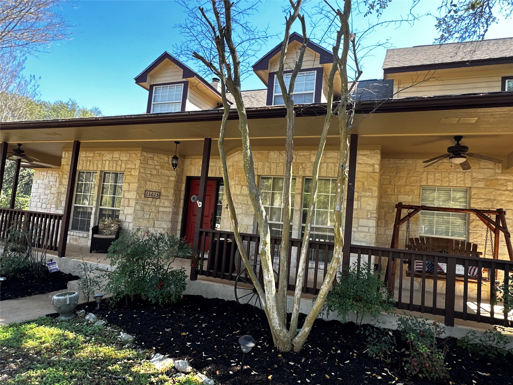 13615 Copperleaf Trail Manchaca, TX 78652 - Photo 2 of 39 View of front of property with a ceiling fan, stone siding, and covered porch