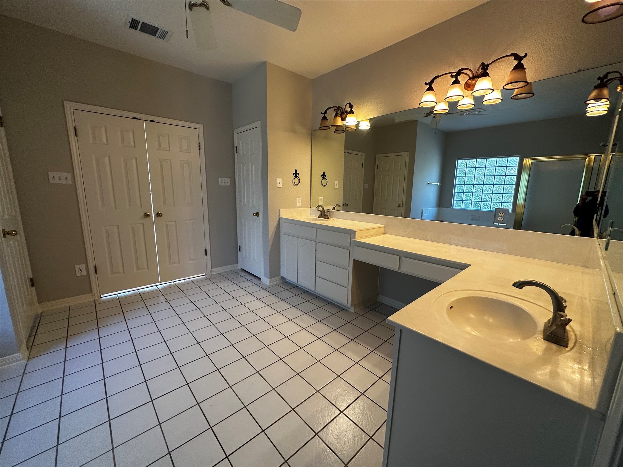 13615 Copperleaf Trail Manchaca, TX 78652 - Photo 24 of 39 Bathroom featuring double vanity, a closet, light tile patterned floors, and a stall shower