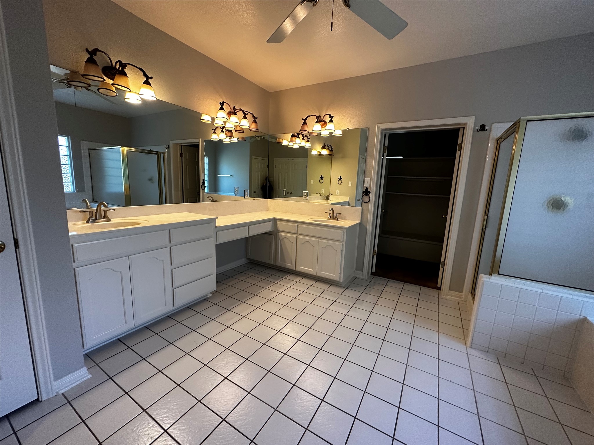 13615 Copperleaf Trail Manchaca, TX 78652 - Photo 25 of 39 Full bathroom with a shower stall, double vanity, a ceiling fan, a spacious closet, and light tile patterned floors