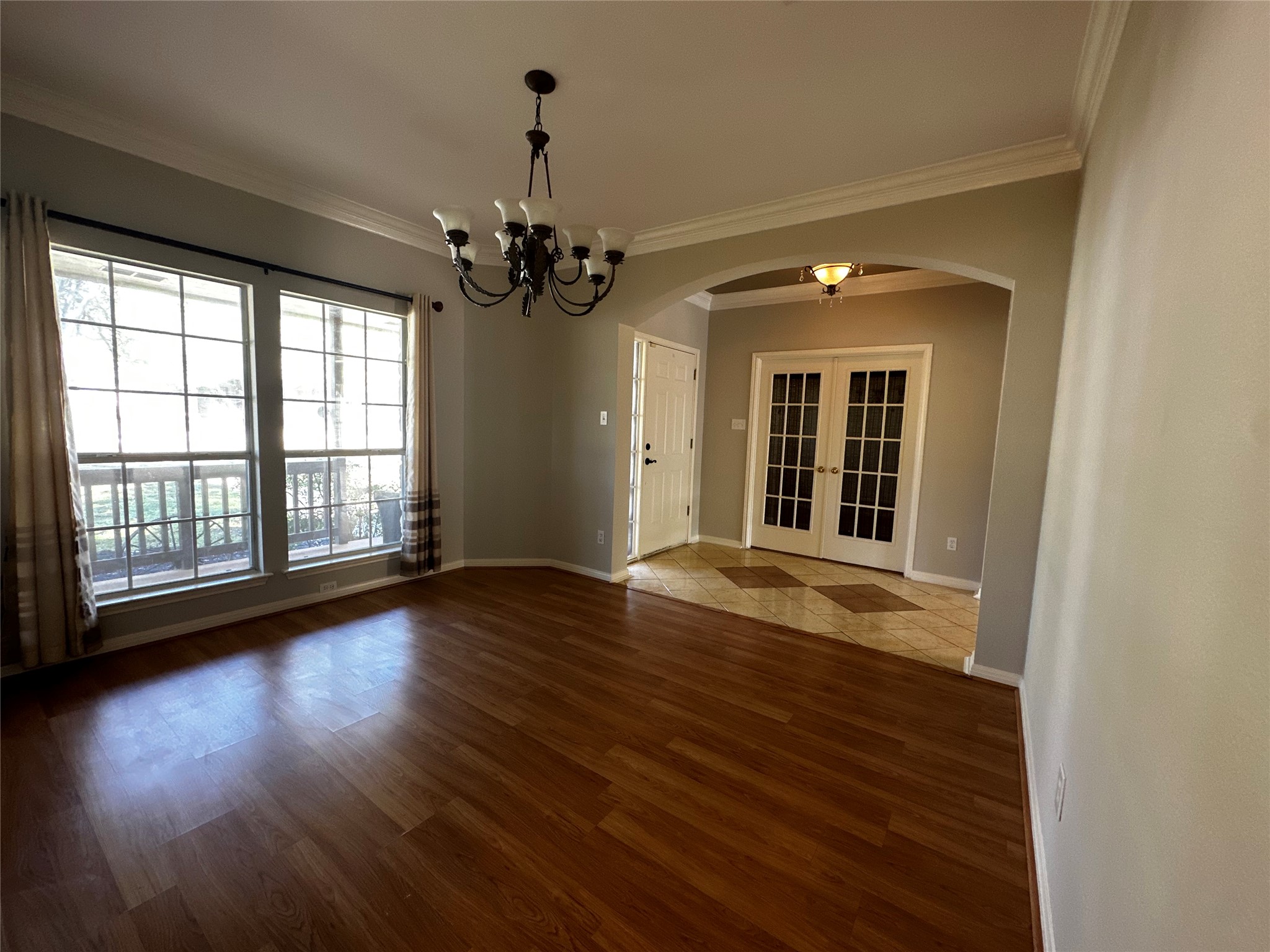 13615 Copperleaf Trail Manchaca, TX 78652 - Photo 7 of 39 Spare room featuring french doors, ornamental molding, hanging lights, arched walkways, and dark wood-style flooring