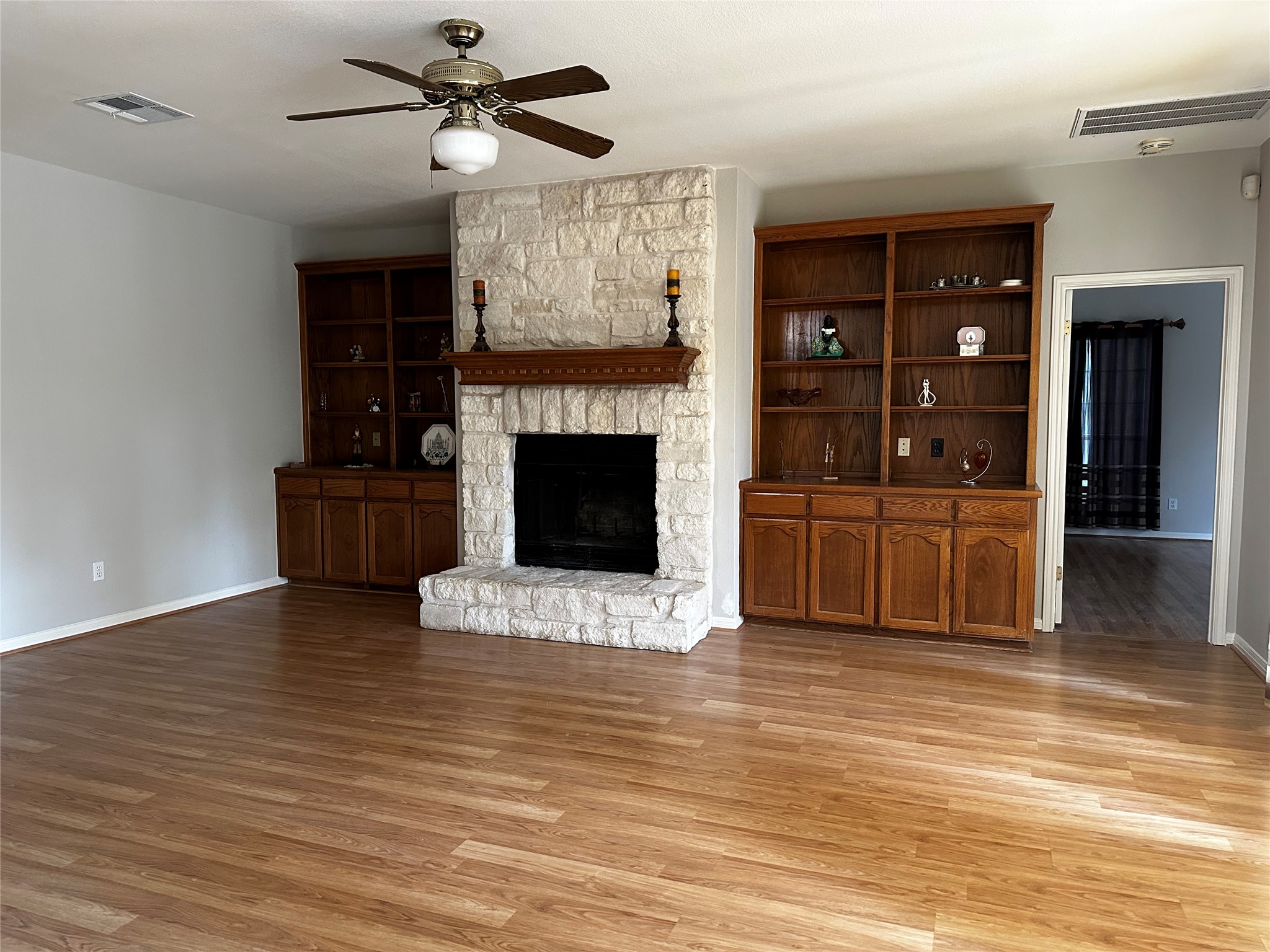 13615 Copperleaf Trail Manchaca, TX 78652 - Photo 8 of 39 Unfurnished living room featuring ceiling fan, light wood-style flooring, and a fireplace