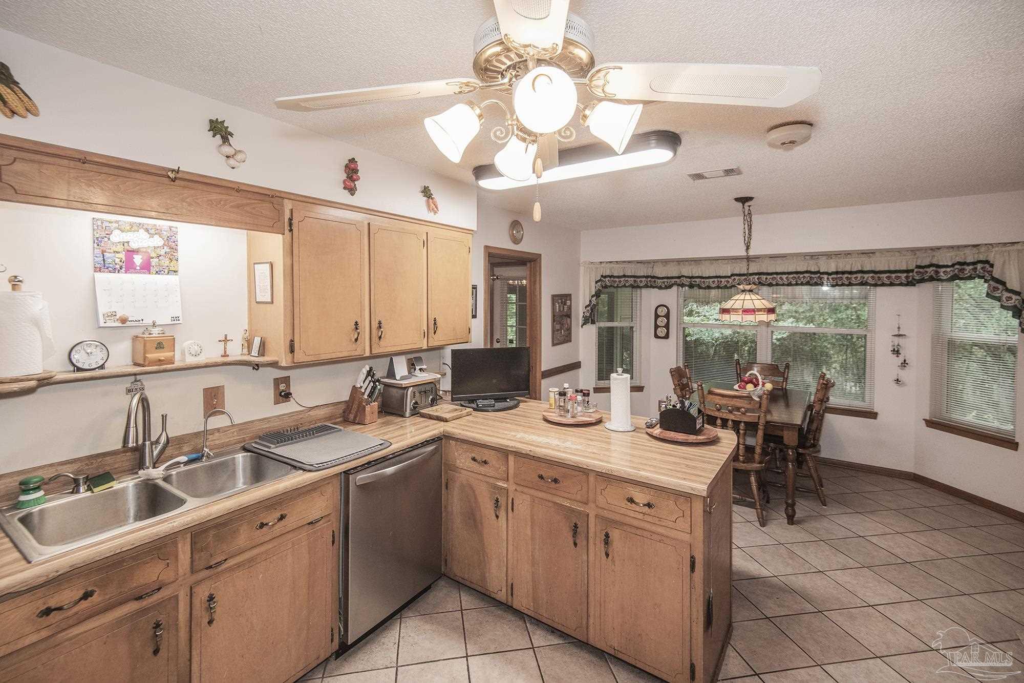 1210 Goldenrod Road Cantonment, FL 32533 - Photo 10 of 50 a kitchen with a sink stove and cabinets