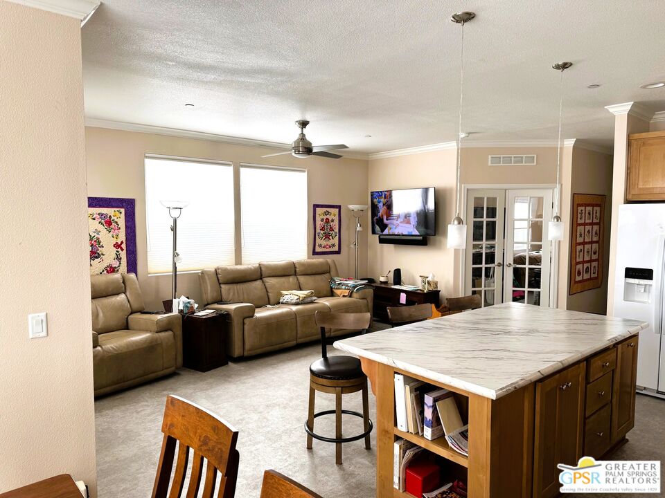 17640 Corkill Road, Unit 37 Desert Hot Springs, CA 92241 - Photo 10 of 35 a living room with furniture a table and kitchen view