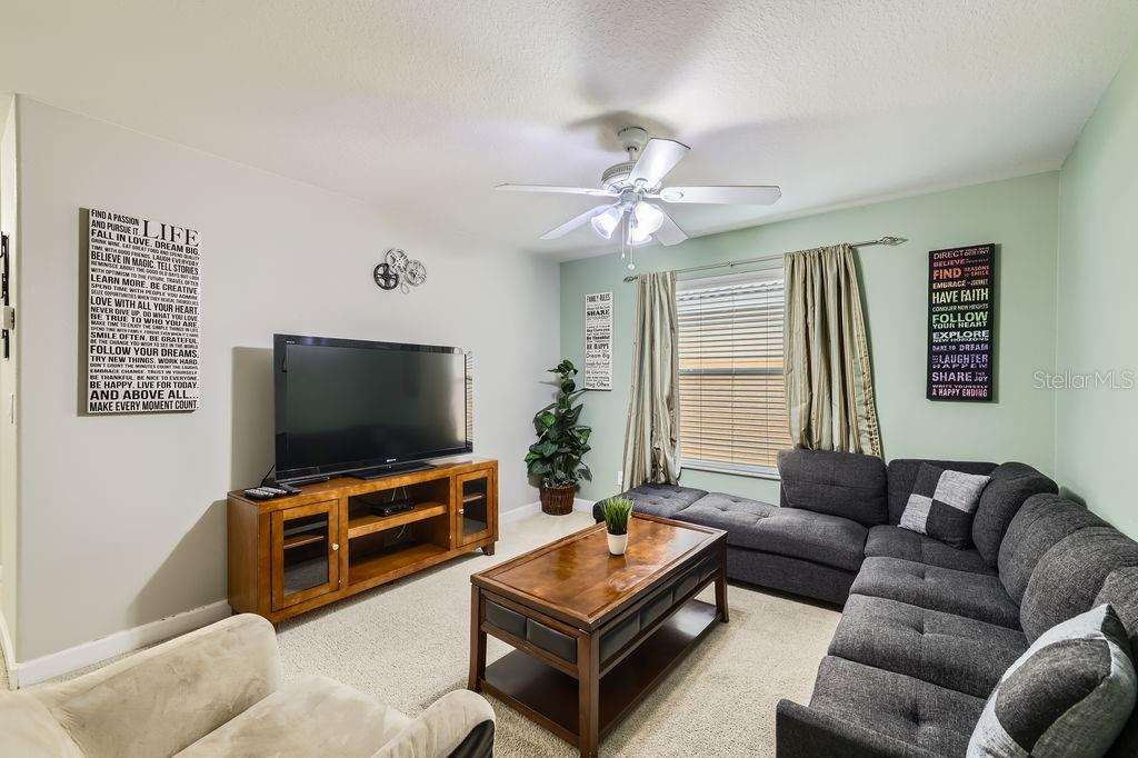 8989 Cuban Palm Road Kissimmee, FL 34747 - Photo 15 of 49 a living room with furniture and a flat screen tv