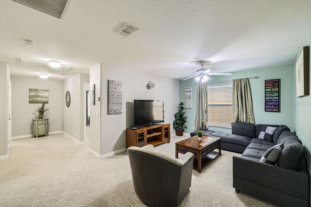 8989 Cuban Palm Road Kissimmee, FL 34747 - Photo 16 of 49 a living room with furniture and a flat screen tv