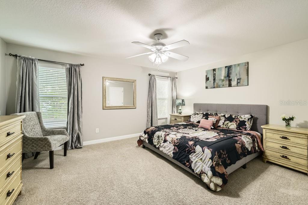 8989 Cuban Palm Road Kissimmee, FL 34747 - Photo 17 of 49 a bedroom with a bed and a chandelier