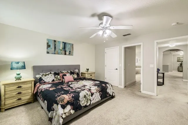 a bedroom with a large bed and a chandelier