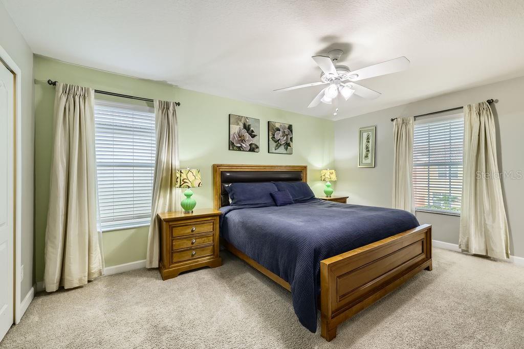 8989 Cuban Palm Road Kissimmee, FL 34747 - Photo 25 of 49 a bedroom with a bed and a chandelier