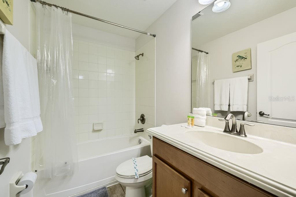 8989 Cuban Palm Road Kissimmee, FL 34747 - Photo 28 of 49 a bathroom with a granite countertop sink toilet and shower