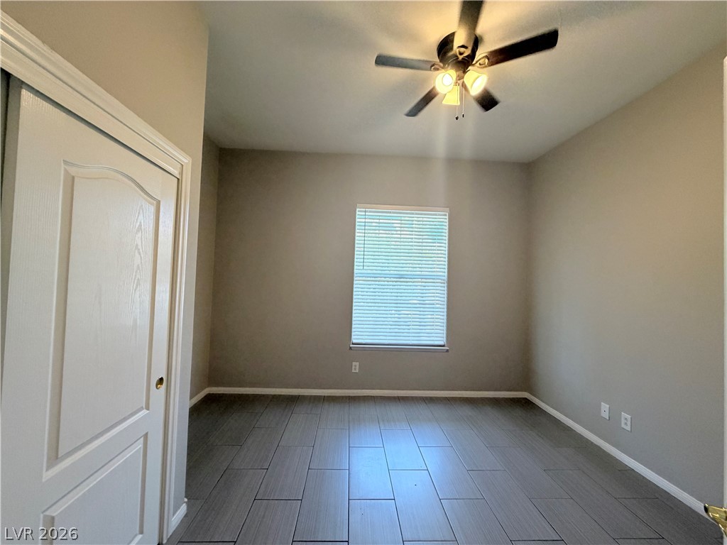 6116 Rabbit Track Street Las Vegas, NV 89130 - Photo 20 of 28 A quiet bedroom featuring elegant tile flooring and a ceiling fan for optimal comfort.