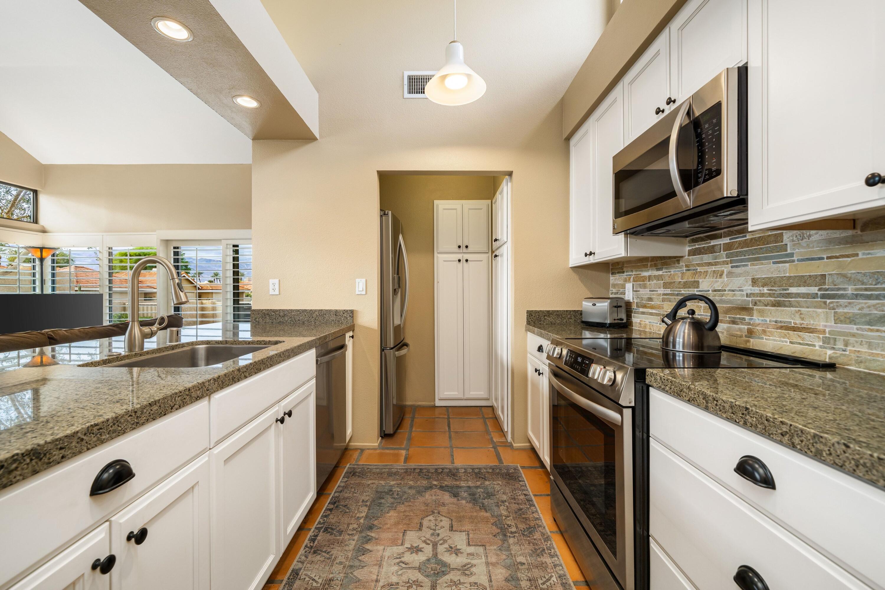 29 Verde Way Palm Desert, CA 92260 - Photo 5 of 43 a kitchen with stainless steel appliances granite countertop a sink stove and refrigerator