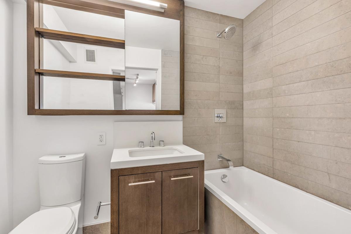 225 Rector Place, Unit 2DD Manhattan, NY 10280 - Photo 3 of 12 a bathroom with a sink a toilet and vanity