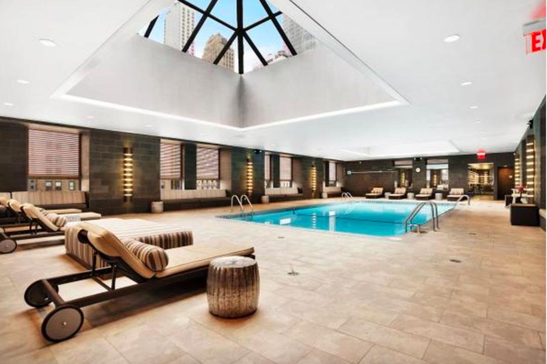 225 Rector Place, Unit 2DD Manhattan, NY 10280 - Photo 5 of 12 a living room with furniture a pool table and a fireplace