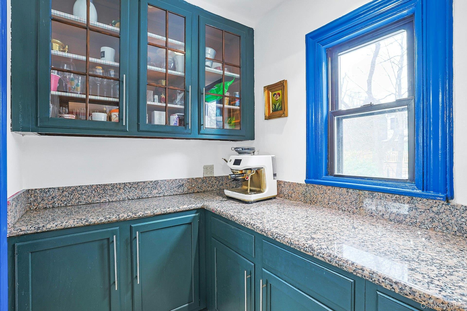 66 Mamaroneck Road Scarsdale, NY 10583 - Photo 14 of 47 A beautifully detailed butler’s pantry with glass-front cabinetry and generous counter space offers both practical storage and a charming connection between the dining area and the kitchen.