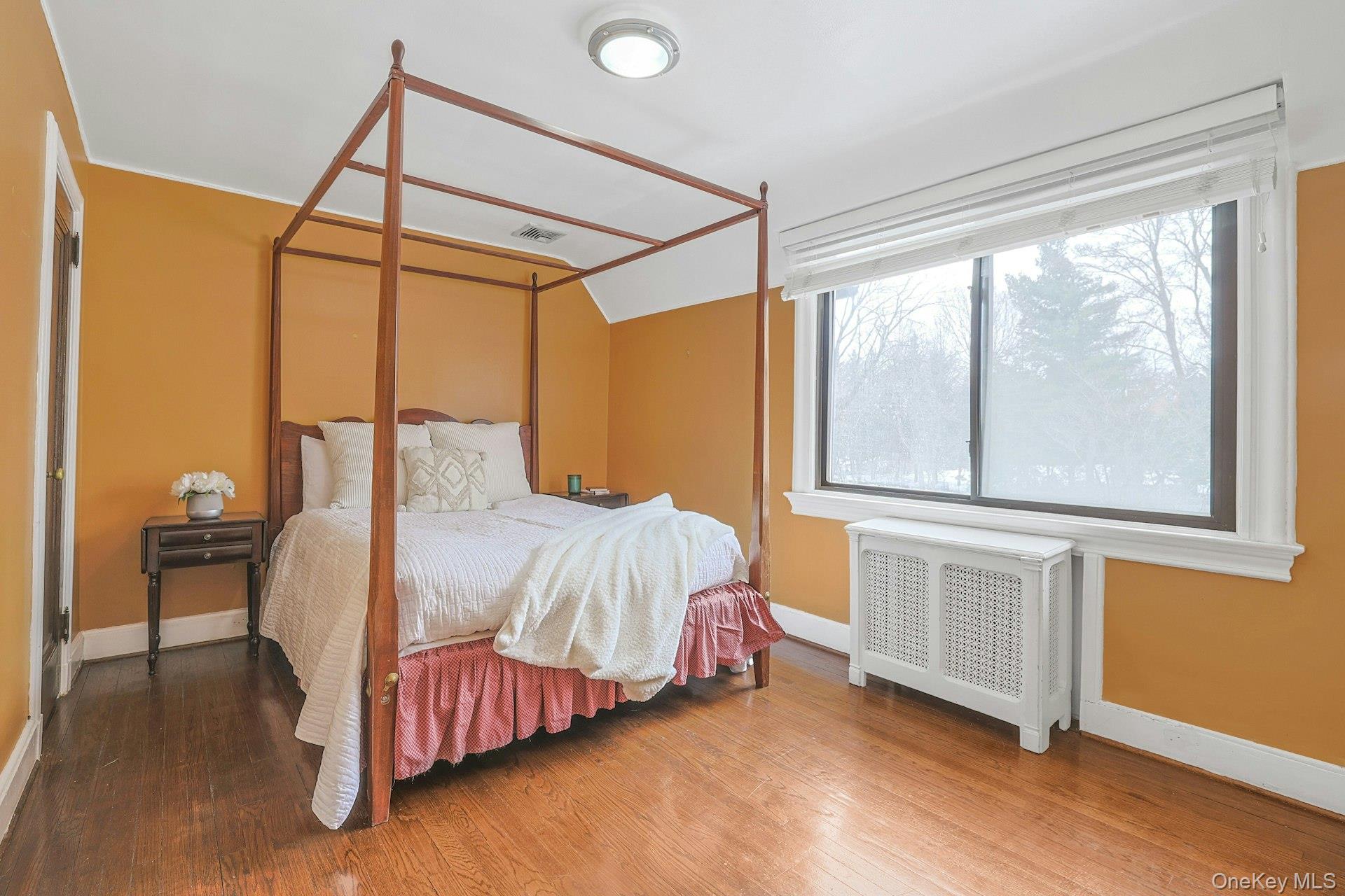 66 Mamaroneck Road Scarsdale, NY 10583 - Photo 24 of 47 A bright and comfortable family bedroom with generous windows and warm hardwood floors, offering a welcoming space for rest and relaxation.