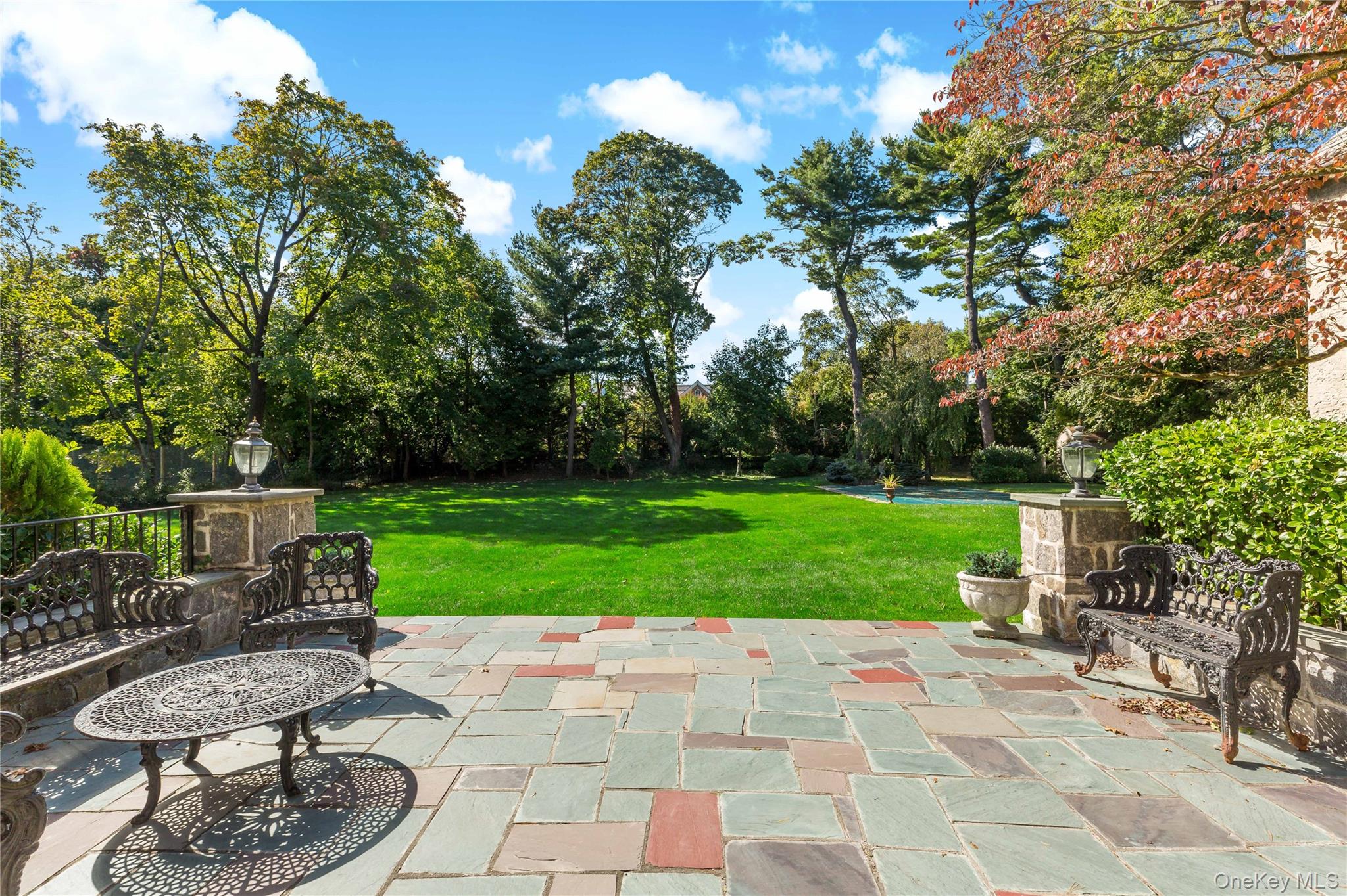 66 Mamaroneck Road Scarsdale, NY 10583 - Photo 33 of 47 An expansive stone patio offers an ideal setting for outdoor entertaining, with wide-open lawn views and a seamless connection to the surrounding grounds.