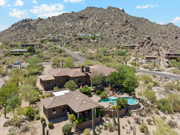 an aerial view of a house with a yard swimming pool and mountain view