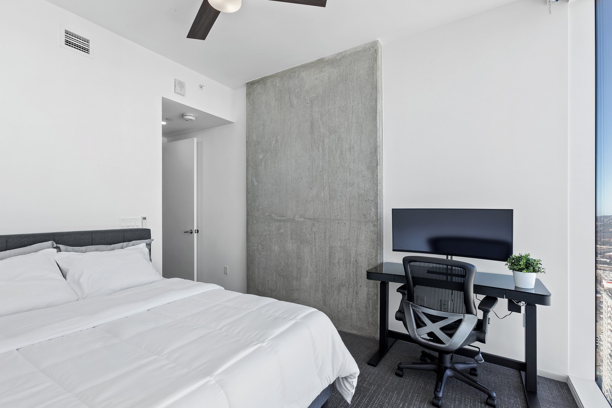301 West Avenue, Unit 5002 Austin, TX 78701 - Photo 15 of 39 a bedroom with a bed and a computer on a desk