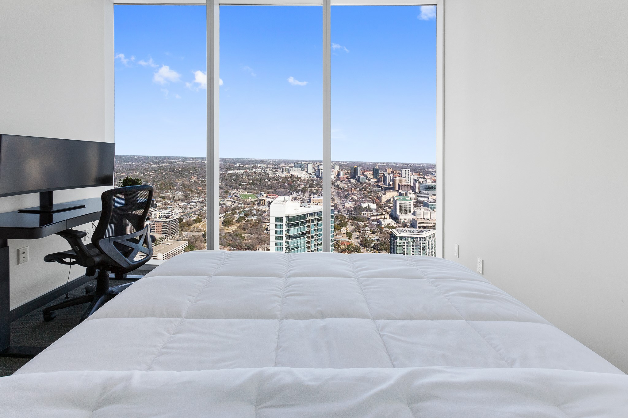 301 West Avenue, Unit 5002 Austin, TX 78701 - Photo 16 of 39 a view of a living room with a floor to ceiling window and a flat screen tv
