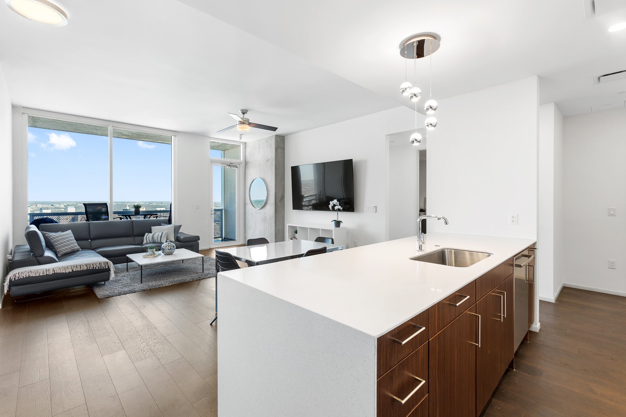 301 West Avenue, Unit 5002 Austin, TX 78701 - Photo 4 of 39 a large living room with stainless steel appliances kitchen island granite countertop a sink and a flat screen tv