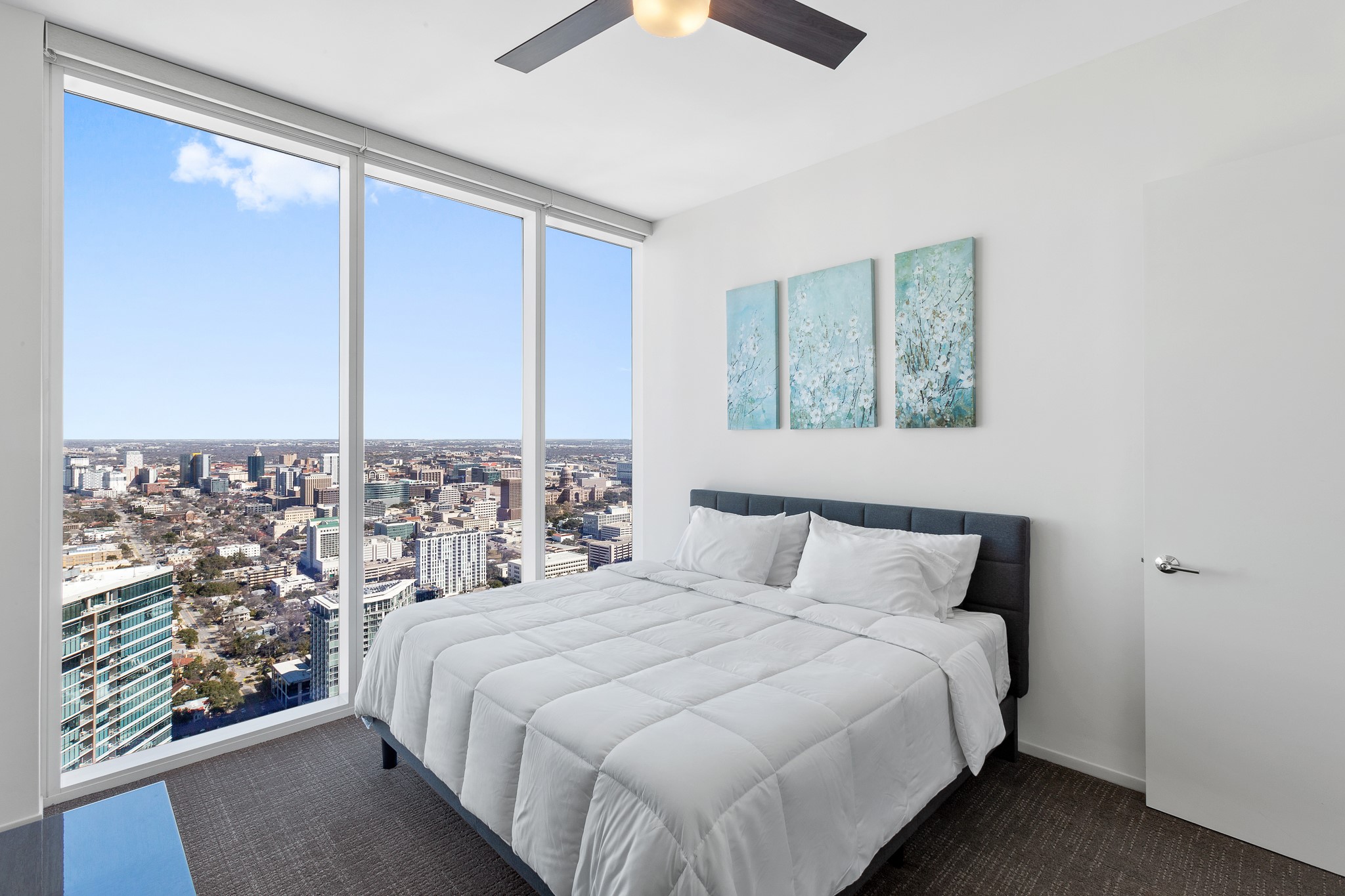 301 West Avenue, Unit 5002 Austin, TX 78701 - Photo 10 of 39 a bedroom with a large bed and a chandelier fan