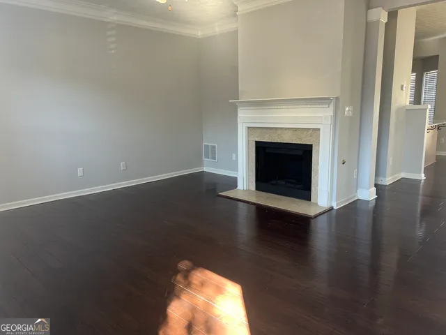 a view of a livingroom with wooden floor and a fireplace