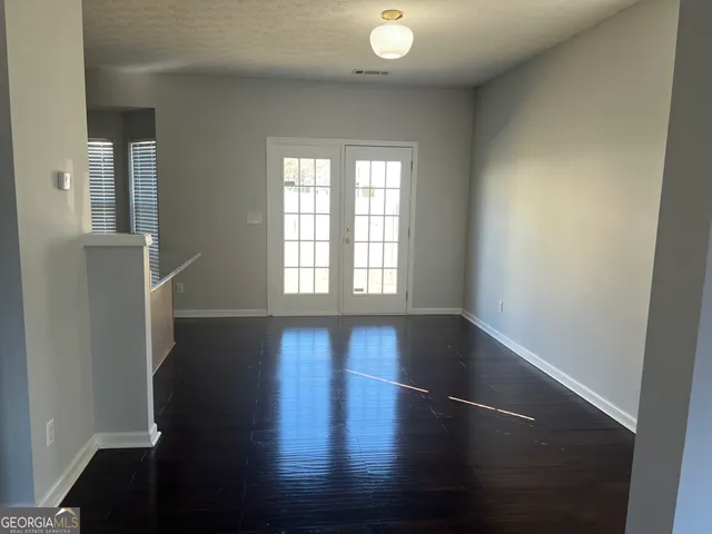 an empty room with wooden floor and windows