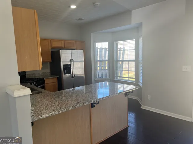 a kitchen with stainless steel appliances granite countertop a sink a stove and a refrigerator