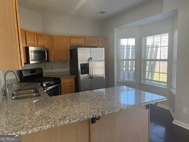 a kitchen with stainless steel appliances granite countertop a sink refrigerator and microwave