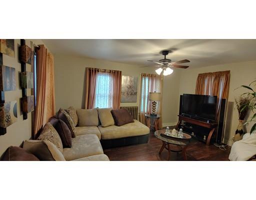 115 Allen Street Springfield, MA 01108 - Photo 3 of 21 a living room with furniture a flat screen tv and a refrigerator