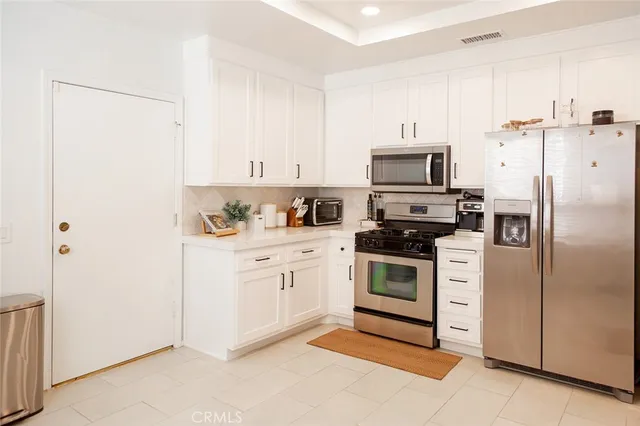a kitchen with cabinets stainless steel appliances and a counter space