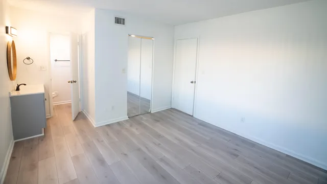 a view of a room with wooden floor and a bathroom