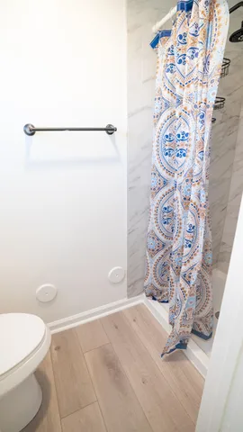 a bathroom with a toilet and a shower curtain