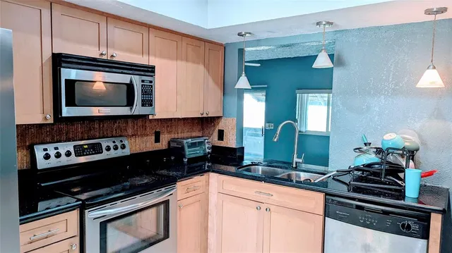a kitchen with granite countertop a stove and a microwave