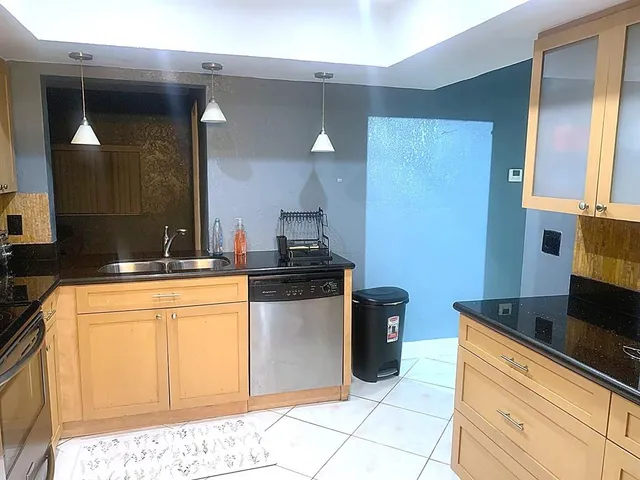 a kitchen with stainless steel appliances granite countertop a sink stove and cabinets