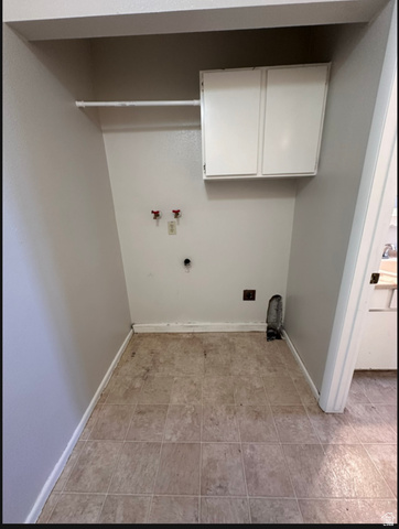 102 East Richelman Lane Wellington, UT 84542 - Photo 14 of 14 Recessed laundry area with tiled flooring, white upper cabinetry, and a hanging rod