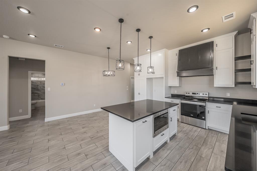 112 Stevens Street Bridgeport, TX 76426 - Photo 11 of 37 a kitchen with stainless steel appliances kitchen island granite countertop a stove a sink and a refrigerator