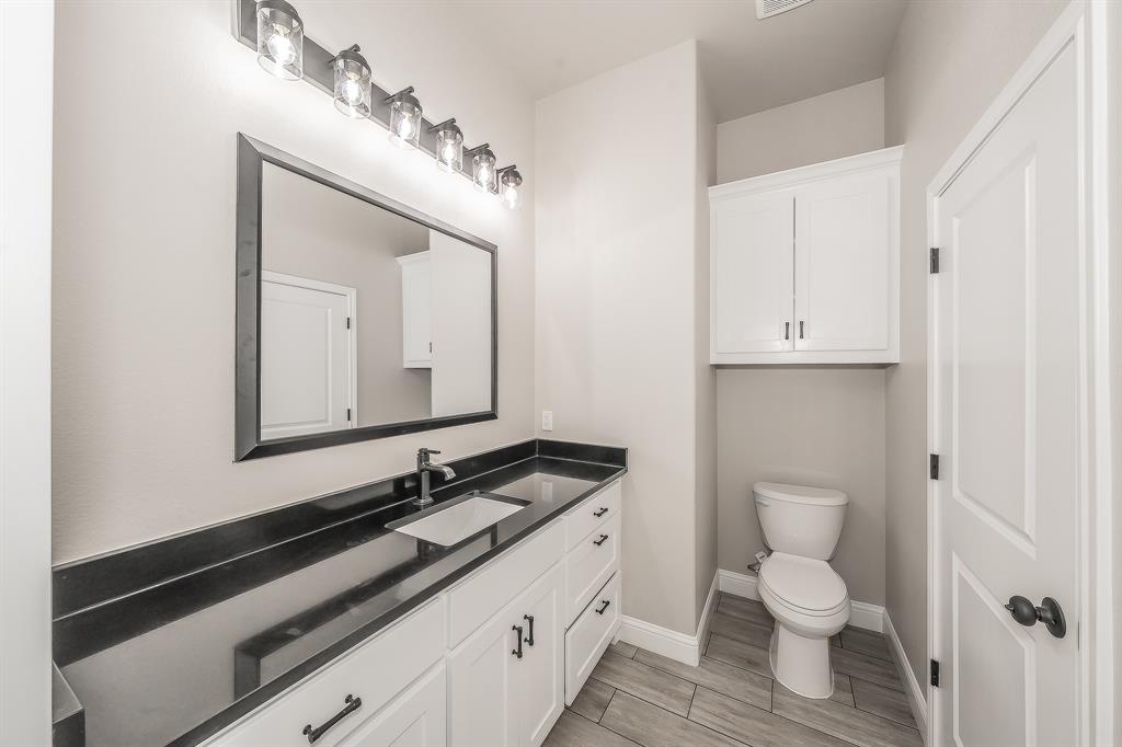112 Stevens Street Bridgeport, TX 76426 - Photo 29 of 37 a bathroom with a granite countertop toilet sink and mirror