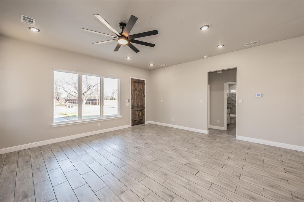112 Stevens Street Bridgeport, TX 76426 - Photo 6 of 37 a view of an empty room with a window and wooden floor