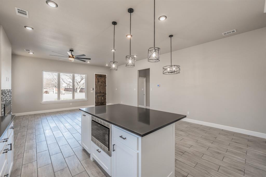 112 Stevens Street Bridgeport, TX 76426 - Photo 10 of 37 a kitchen with kitchen island a counter space a sink appliances and a living room view