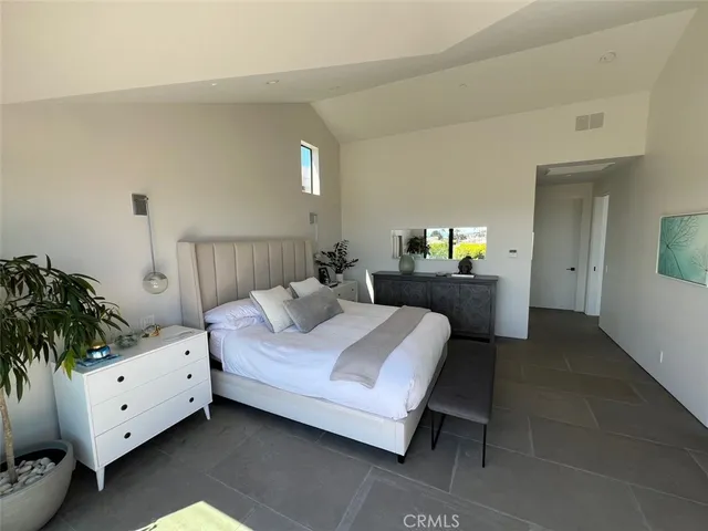 a bedroom with a bed and a potted plant