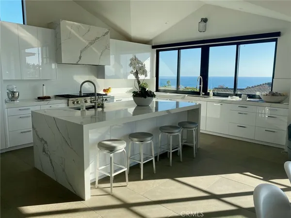 a kitchen with stainless steel appliances granite countertop sink stove and white cabinets