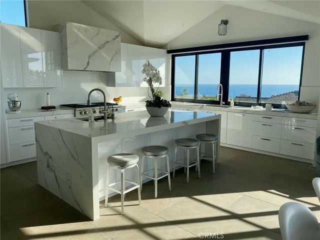 a kitchen with stainless steel appliances granite countertop sink stove and white cabinets