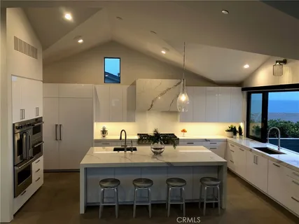 a kitchen with a sink and chairs