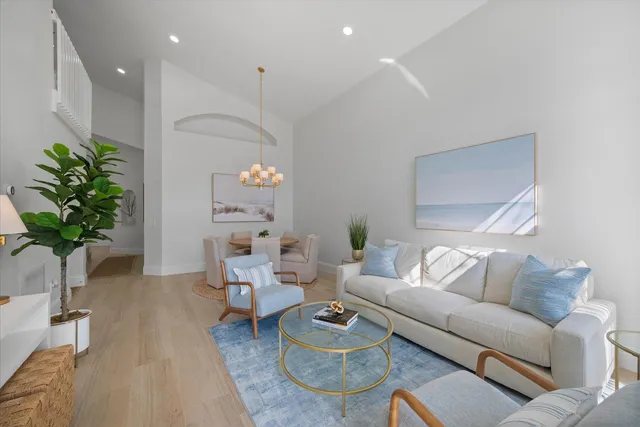a living room with furniture a chandelier and a potted plant