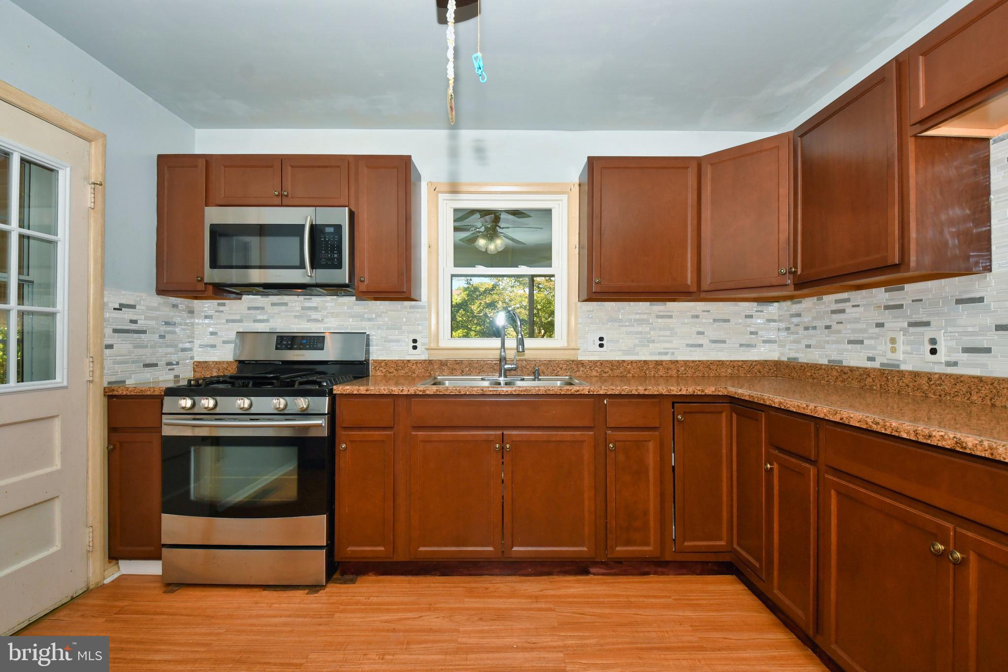 4704 Ebenezer Road Nottingham, MD 21236 - Photo 10 of 56 a kitchen with stainless steel appliances granite countertop a stove a sink and a microwave