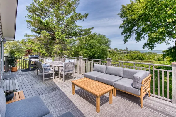 a view of a patio with couches and a table and chairs with wooden floor