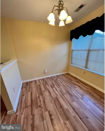 a view of a room with wooden floor and chandelier