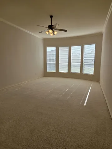 a view of an empty room with a chandelier fan